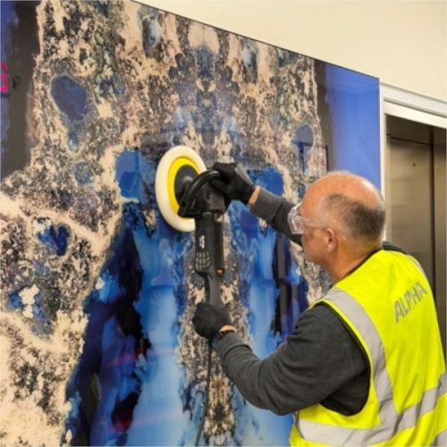 Worker using Alpha BMP-700 Brushless Variable Speed Rotary Polisher on a vertical stone surface