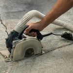 Worker using Alpha ECC-125 Ecocutter on a concrete surface