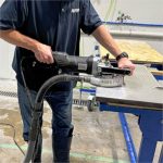 Worker using Alpha Ecoguard 7″ Grinding Kit along a stone slab edge