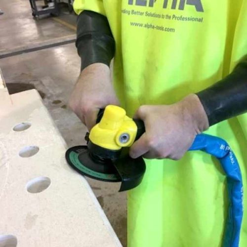Worker using ALPHA PSC-600 Pneumatic Stone Cutter along a stone edge