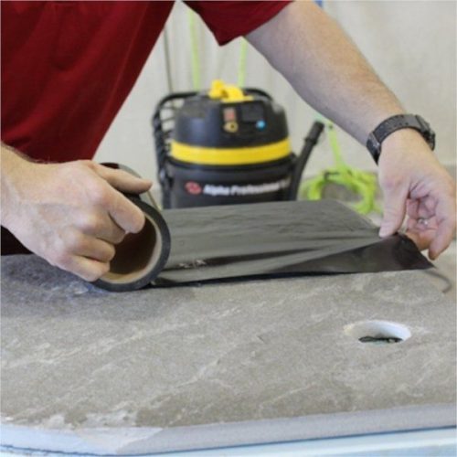 Worker positioning Alpha Surface Protection Tape on a stone surface