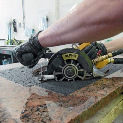 Worker cutting stone over Alpha Surface Protection Tape
