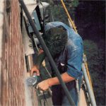 Worker operating Alpha Tuck Point on an exterior brick wall