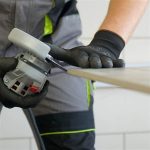 Worker using DiStar Edge Dry 4.5″ diamond blade for tile edge miter cutting