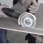 Worker using DiStar Perfect 4.5″ diamond blade to cut porcelain tile