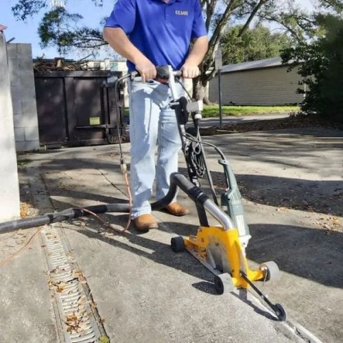 Worker using Mark-III Dust Buggy to clean a joint in a concrete surface