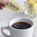 In-use view Splenda Sugar Packet for beverage sweetening