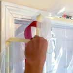 Close-up ZipDoor Standard Door Kit adhesive attachment on a doorframe