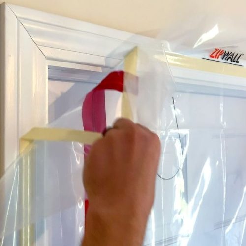 Close-up ZipDoor Standard Door Kit adhesive attachment on a doorframe