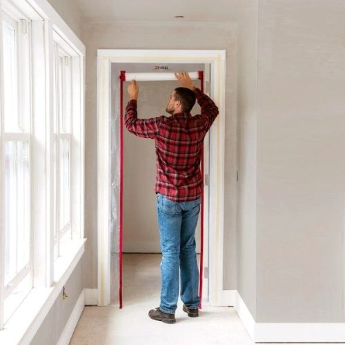 Worker securing ZipDoor Standard Door Kit above a residential doorway