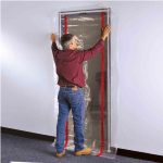 Worker installing ZipDoor Standard Door Kit across a doorway