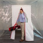Person passing through ZipDoor Magnetic Door Kit installed in a commercial containment area