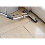 Worker using Hydro-Force 14-inch Gekko Brush Head to clean a hard floor surface