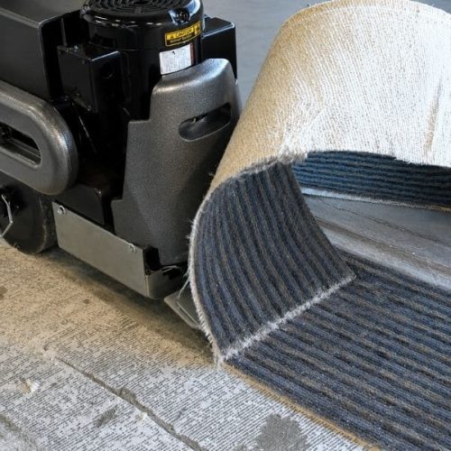 Worker using National Self-Propelled Walk Behind Scraper during floor removal