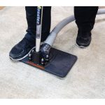Worker using Water Claw Flash Extractor II for carpet water extraction